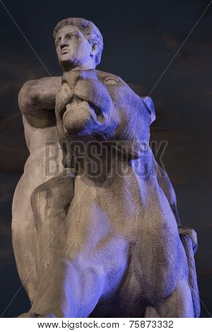 A stone sculpture of a man with a panther