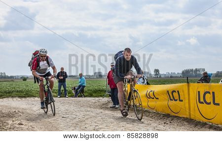 Amateur Cyclists Riding On A Cobblestoned Road