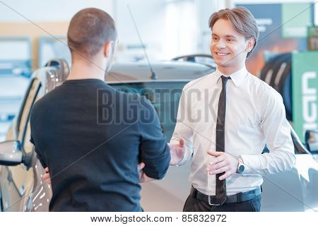 Customer and sales consultant with showroom view on the backgrou