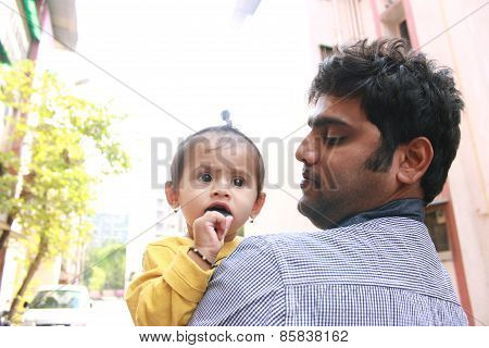 Indian Man holding kid and looking at her with love