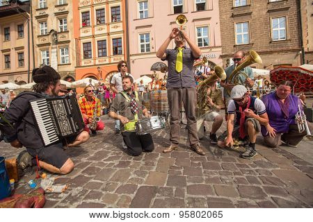 KRAKOW, POLAND - JUL 12, 2015: Participants at the annually (July 9-12) 28th International Festival of Street Theatres - Orchestre International du Vetex (Belgium/France) in the Main Square of Krakow.