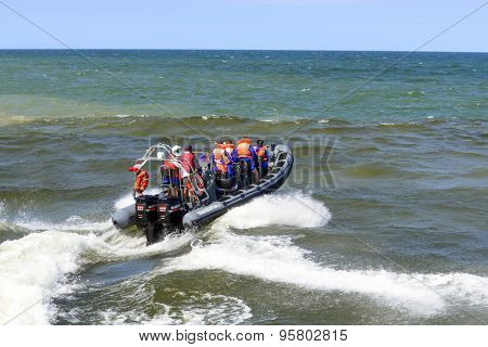 USTKA - JULY 07: Tourists enjoy a high speed boat ride on the Baltic sea near the harbour on 7 July 2015 in Ustka, Poland.