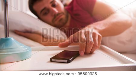 Man In Bed Woken By Alarm On Mobile Phone