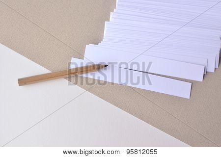 Paper stripes for notes with pencil on a paper beige background