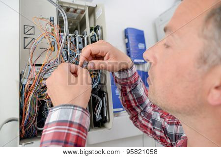 Electrician repairing a fusebox