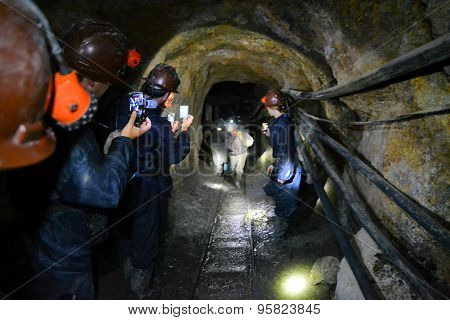 Potosi, Bolivia - 24 November 2012: Tourists inside the Cerror Rico silver mine film miners. Potosi is one of the highest cities in the world and has a history for extraction of rich silver deposits.