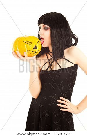 Kvinde i sort kjole holder en Jack-o'-lantern