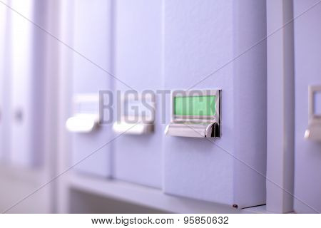 File folders, standing on  shelves in the background