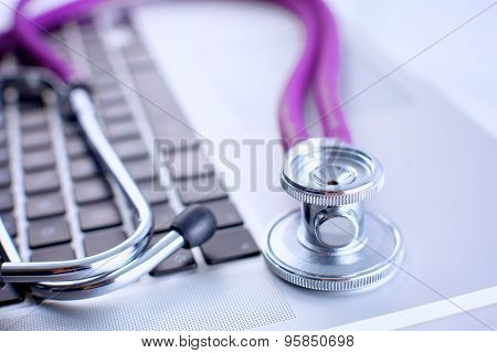 Violet stethoscope on a laptop computer