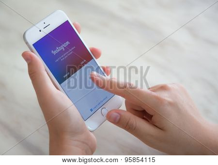 Loei, Thailane - July 12, 2015: Hand holding Iphone with mobile application for Instagram on the screen