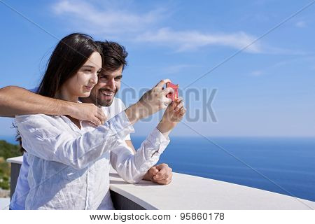 happy young couple taking selfie with cell phone