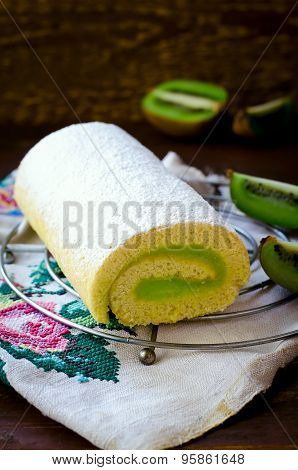 Roll cake witn kiwi cream decorated macarons