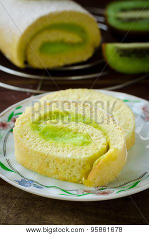 Roll cake with kiwi cream decorated macarons