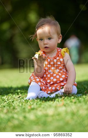 happy young baby child sittng on grass on beautiful summer day in park