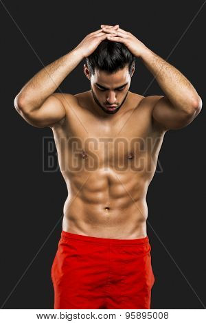 Portrait of a handsome and sexy man, isolated over gray background