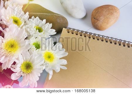 Blank Area Note Book Or Diary With Flower And Pebble