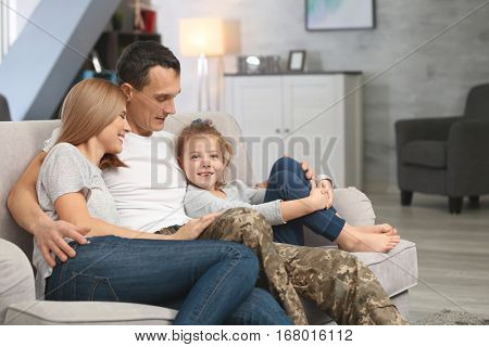 Military father with his family on sofa at home