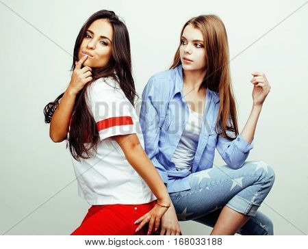 best friends teenage girls together having fun, posing emotional on white background, besties happy smiling, lifestyle people concept, blond and brunette multi nations close up
