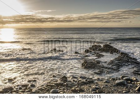 A view of the Indian Ocean with rocks in the foreground in the early morning in East London South Africa near Eastern Beach.