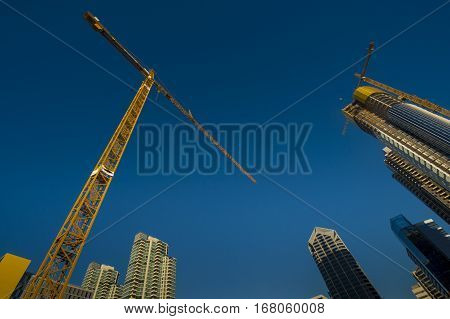 High rise crane in among tall buildings