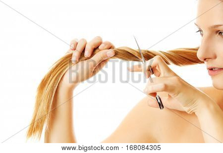 Attractive young woman is cutting her long natural hair