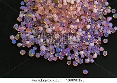 Macro of silica gel balls laying on black background.Its use to prevent mold, mildew, corrosion, odours and other moisture damage.