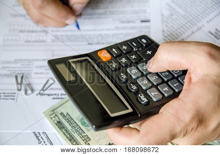 Cropped image of Businessman calculating and checking tax