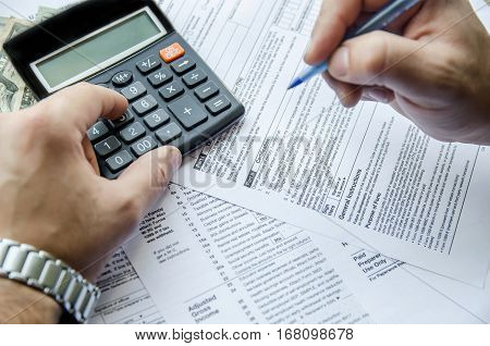 Cropped image of Businessman calculating and checking tax