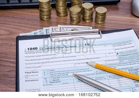 US Federal Income 1040 tax return form with money and pen