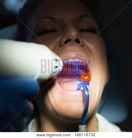 Dentist using curing light.square image, color image