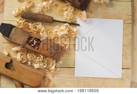 White sheet on wooden table for carpenter tools with sawdust. Copy space. Top view.