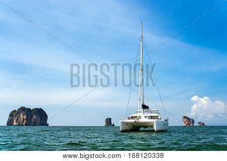 Yachts on the background of rocks. Yacht at sea