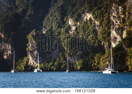 Yachts on the background of rocks. A huge mountain in the background
