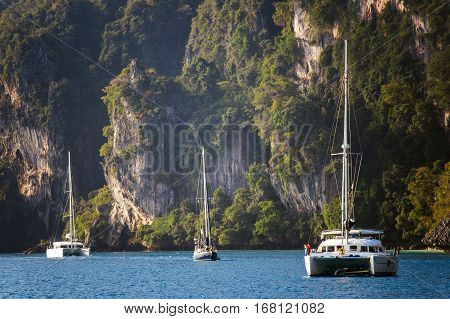 Yachts on the background of rocks. A huge mountain in the background