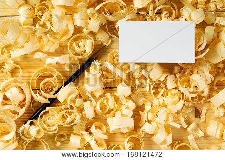 Blank business card on wooden table for carpenter tools with sawdust.Copy space. Top view.