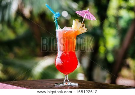 Pin Orange cocktail with ice on the background of the tropics. A cold drink in the tropics