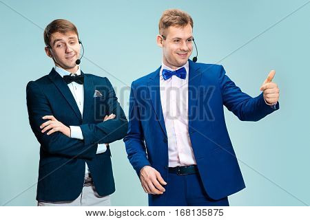 Portrait of a handsome customer service operator wearing a headset isolated on blue studio background