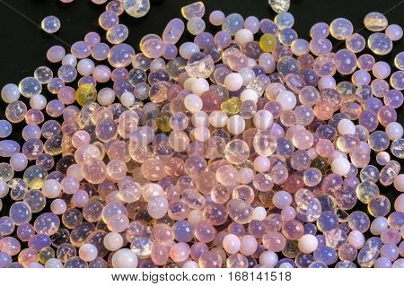 Macro of silica gel balls laying on black background.Its use to prevent mold, mildew, corrosion, odours and other moisture damage.