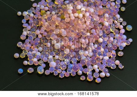 Macro of silica gel balls laying on black background.Its use to prevent mold, mildew, corrosion, odours and other moisture damage.