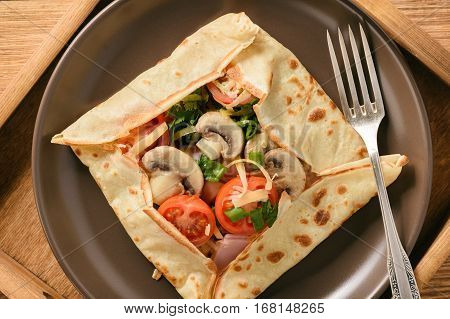 Pancakes sutffed with ham, cheese, tomatoes and mushrooms.