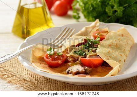 Pancakes sutffed with ham, cheese, tomatoes and mushrooms.