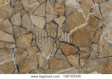 Background of a stone wall cladding texture brown stone bricks