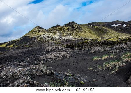 Volcanic landscape in Lakagigar with saturated green moss black volcanic sand and craters on Iceland