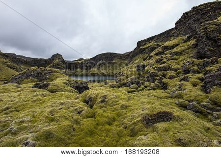 Laki crater lake Tjarnargigur on Iceland with green moss