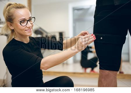Happy Woman Fastening Belt On Man Leg