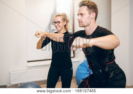 Female Coach Training Man With Ems