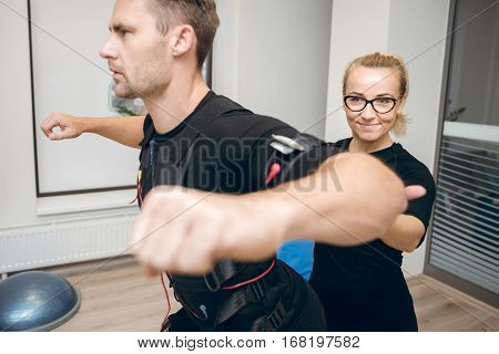 Beautiful Female Coach Training Man With Ems