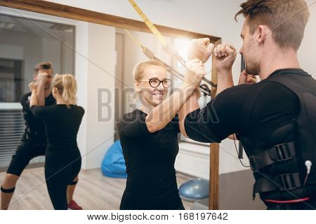 Happy Female Coach Training Man At Gym