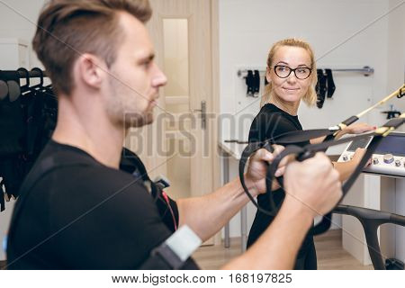 Satisfied Female Coach Looking At Man Training