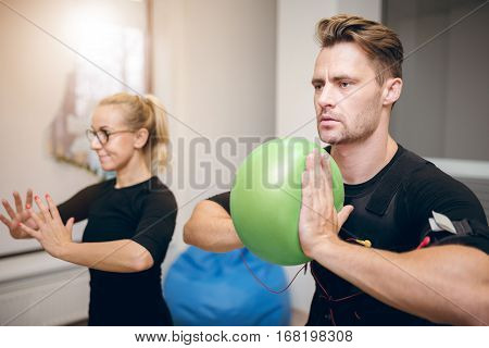 Serious Man On Ems Training With Coach At Gym